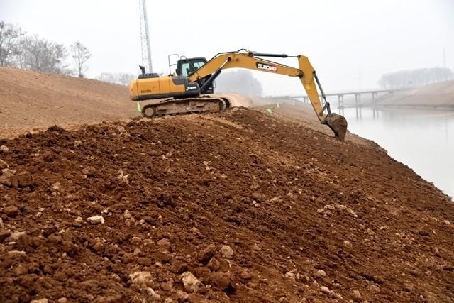 几台大型挖掘机挥舞铁臂正在进行河道清淤疏浚和填筑作业